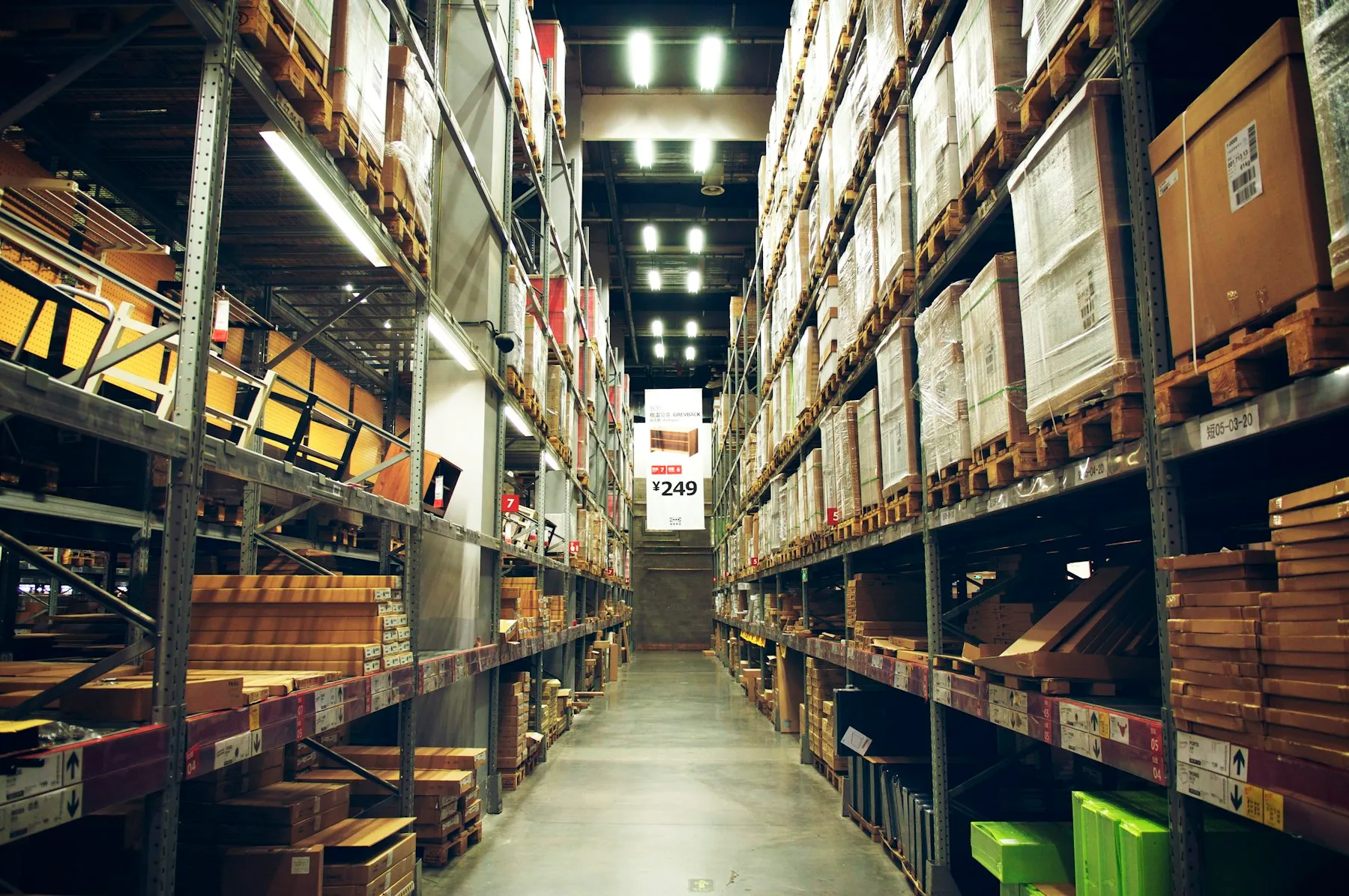 Pasillo de bodega con estanterías altas llenas de cajas de inventario