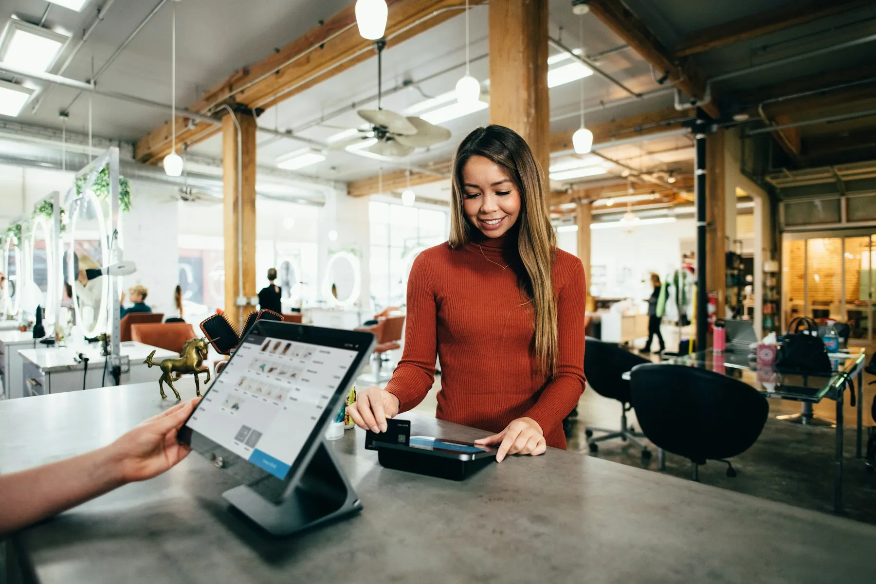 Persona del equipo atendiendo el punto de pago de una tienda